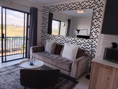 a living room with a couch and a mirror at The Lagoon in Pretoria