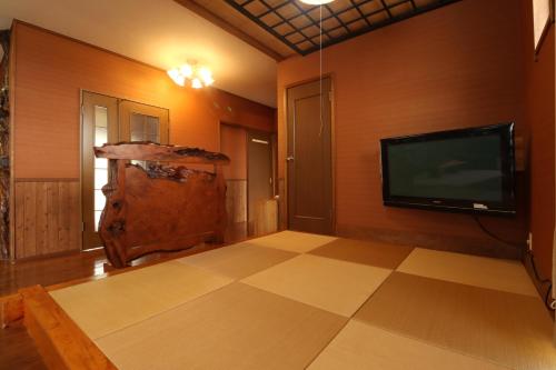 a living room with a flat screen tv on the wall at 別荘五岳 in Minami Aso