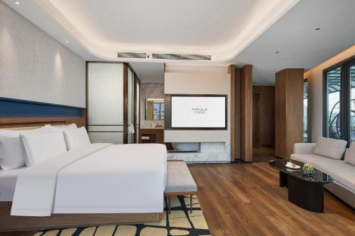 a bedroom with a white bed and a tv at Arula Mianyang Jianshan Hotel-绵阳见山檀程酒店 in Mianyang