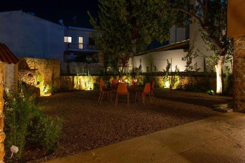 a backyard with a table and chairs at night at Stone residence across Eiffel's Tower - Filiatro 2 in Filiatra
