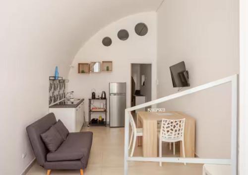 Una sala de estar con una mesa de comedor y una cocina. en affitta camere fieramosca, en Barletta