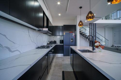 a kitchen with black cabinets and a counter top at Brand New Designer House in Marsden Park