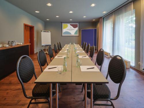 a conference room with a long table and chairs at Classik Hotel Magdeburg in Magdeburg