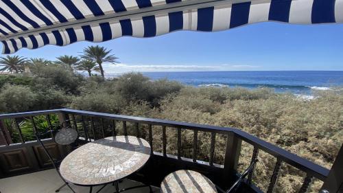 Un balcón con mesa y sillas y el mar. en El BAJIO Nr 6, en Valle Gran Rey