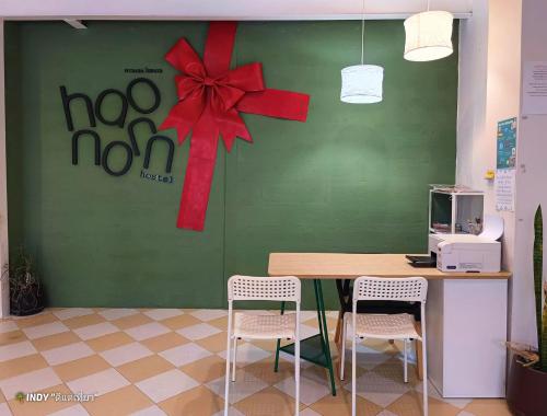 a table with a red bow on a green wall at haonornhostel in Ban Madua Wan