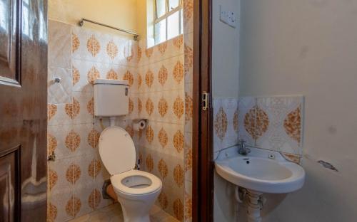 a bathroom with a toilet and a sink at Bremu Home - Near jkia airport in Nairobi