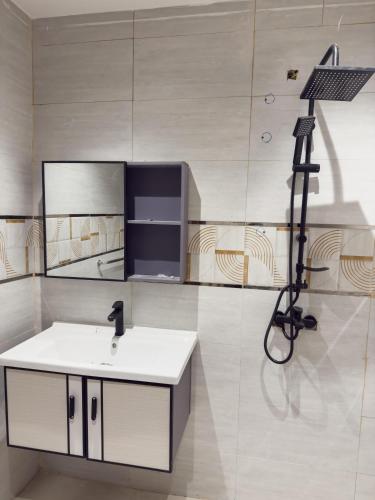 Un baño con un lavabo y una cámara en la pared. en hotel city, en Al Bad‘