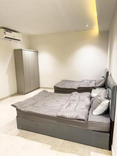 Un dormitorio con dos camas en una habitación. en hotel city, en Al Bad‘