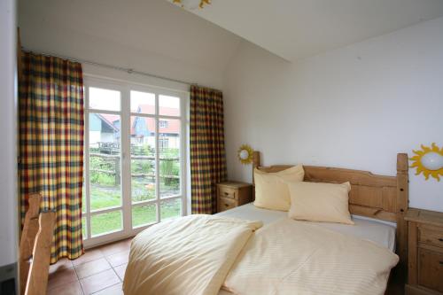 sypialnia z łóżkiem i dużym oknem w obiekcie Hasseröder Ferienpark w mieście Wernigerode