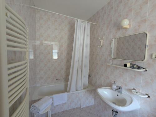 a bathroom with a sink and a tub and a shower at Gründner Vendégház in Siófok