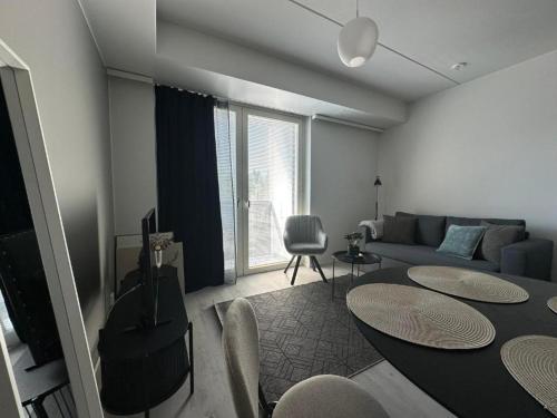a living room with a couch and a table at Pramea Apartments Asematalo in Kuopio