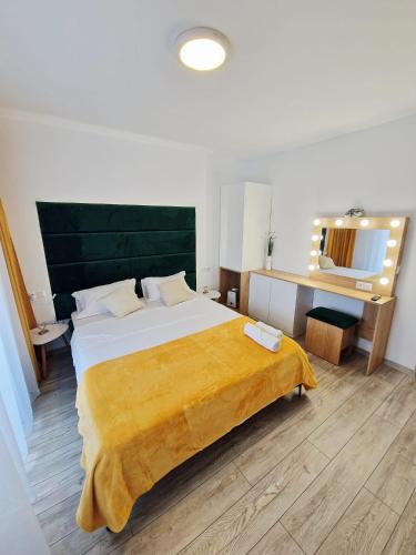 a bedroom with a large bed and a mirror at SaraHome Turda in Turda