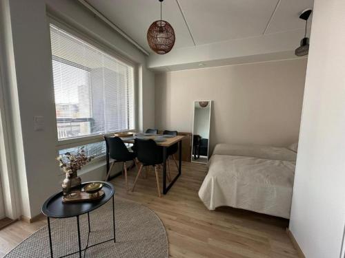 a bedroom with a bed and a table and chairs at Pramea Apartments Asematalo in Kuopio