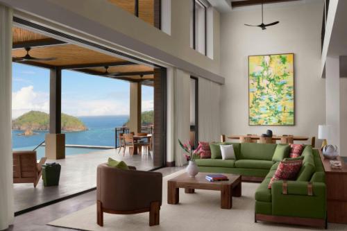 a living room with green furniture and a view of the ocean at Nekajui, a Ritz-Carlton Reserve in Papagayo, Guanacaste