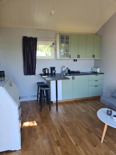 a kitchen with white cabinets and a table at Gäststuga Norafjärden in Sandöverken