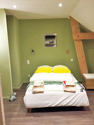 a bedroom with a bed with yellow pillows and a ladder at Chambre Guernesey - Quai des Ormes in Barneville-Carteret