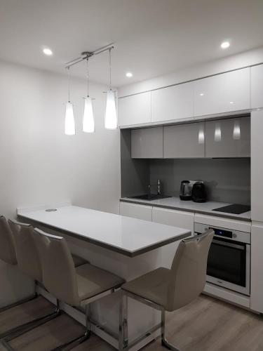 une cuisine avec une table blanche et des chaises dans l'établissement Appartement neuf près de la mer, à Nice