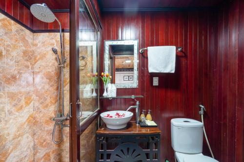 Baño rojo con lavabo y aseo en Sunlight Legend 12 Ha Long Bay, en Ha Long