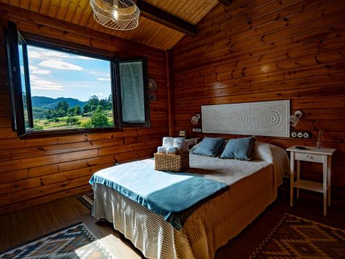 una camera con un letto in una baita di tronchi di Vivienda vacacional El Peñon a Candamin