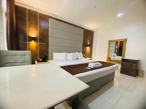 a hotel room with a bed and a table and chair at PRESKEN WHITE HOUSE in Lagos