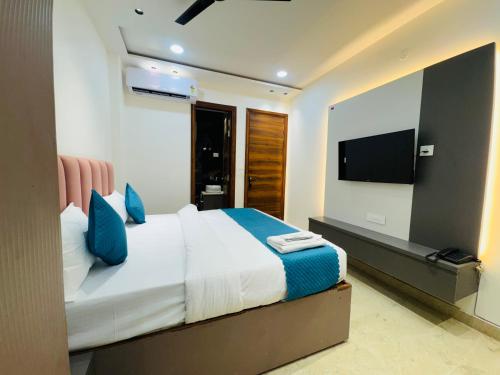 Un dormitorio con una cama grande y un televisor de pantalla plana. en Hotel 7 Star Rohini Sector 17, en Nueva Delhi