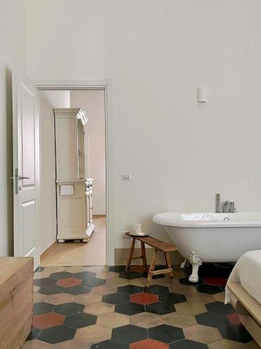 a bathroom with a bath tub and a bedroom at La Cocca Via Saffi, con vasca in camera in Viterbo