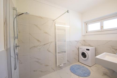 a bathroom with a shower and a washing machine at Fernblick in Sluderno
