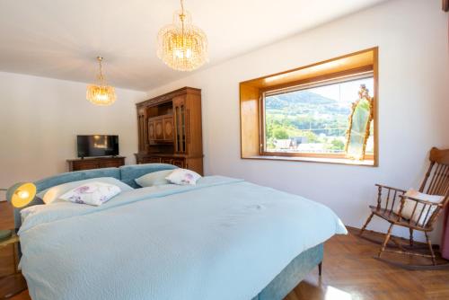 a bedroom with a blue bed and a window at Fernblick in Sluderno