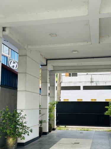 a white building with a black garage door at Lakeview Apartment with Modern Interior and Facilities in Battaramulla