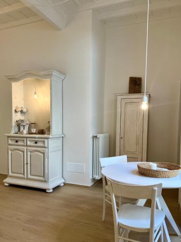 a white dining room with a table and chairs at La Cocca Via Saffi, con vasca in camera in Viterbo