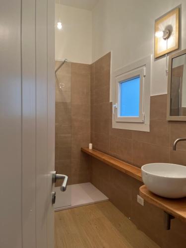 a bathroom with a white sink and a window at La Cocca Via Saffi, con vasca in camera in Viterbo