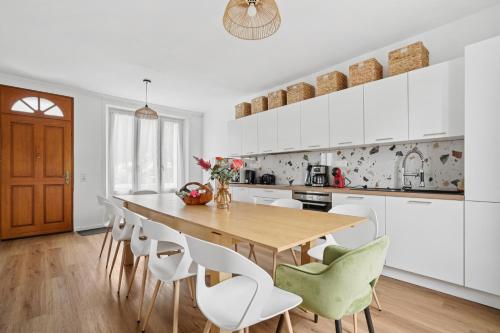 プロエルメルにあるGrande maison familialeのキッチン(木製テーブル、白いキャビネット付)