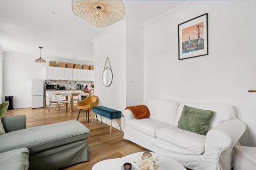 un salon avec des meubles blancs et une table dans l'établissement Grande maison familiale, à Ploërmel