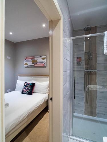 a bedroom with a bed and a glass shower at Kelham Apartments Sheffield in Sheffield