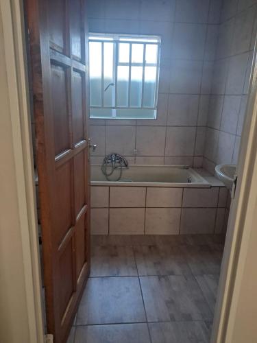 a bathroom with a bath tub and a sink at TCM Guesthouse in Springs