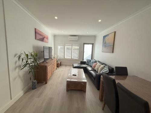 a living room with a couch and a table at Happy BNB at Beach side semaphore park in Port Adelaide