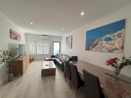a living room with a couch and a table at Happy BNB at Beach side semaphore park in Port Adelaide