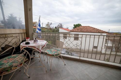 a patio with a table and chairs on a balcony at Eleni's GuestHouse in Ágios Vissaríon