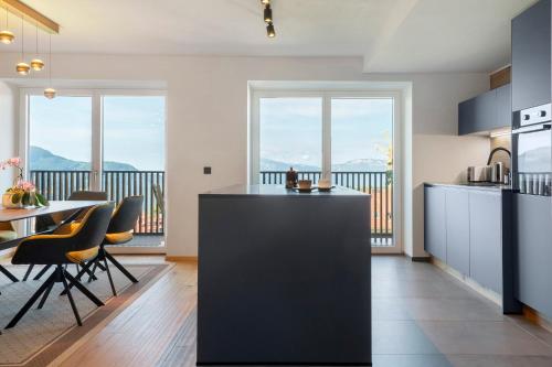 a kitchen with a counter and chairs and a table at Apartment Anna in Soprabolzano