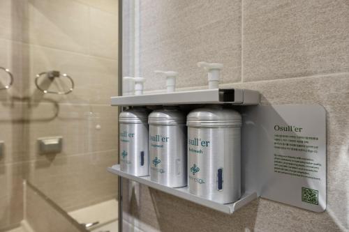 a row of white bottles on a shelf in a bathroom at Marysol by Haeundae beach in Busan