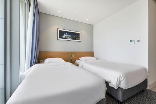 a hotel room with two beds and a window at Marysol by Haeundae beach in Busan