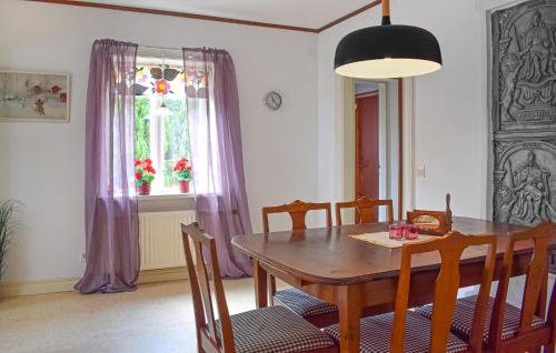 a dining room with a wooden table and chairs at Nice Home In Gärds Köpinge in Gärds Köpinge