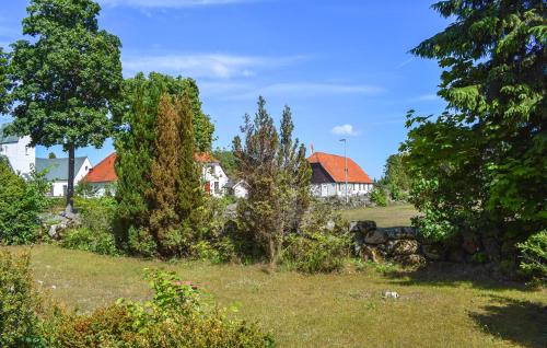 a group of houses in a field with trees at Nice Home In Gärds Köpinge in Gärds Köpinge