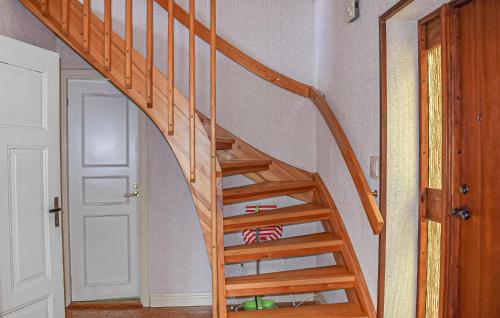 a wooden staircase in a room with a door at Nice Home In Gärds Köpinge in Gärds Köpinge