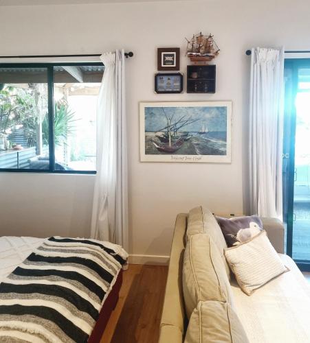 a living room with a couch and a window at Boat Haven Studios in Goolwa