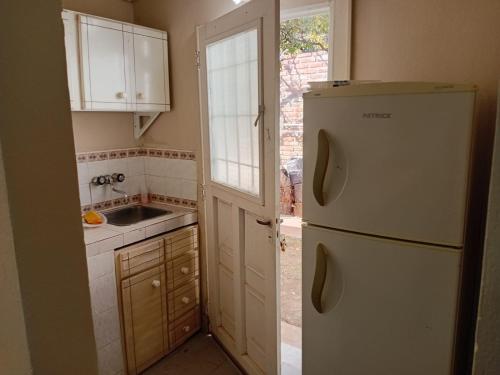 a kitchen with a white refrigerator and a sink at Apart POTRERILLO in San Fernando del Valle de Catamarca