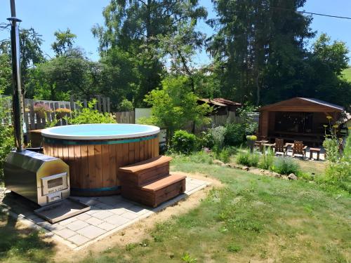 a backyard with a hot tub and a grill at Ferienhaus Cosyhome Vogelsberg in Köddingen