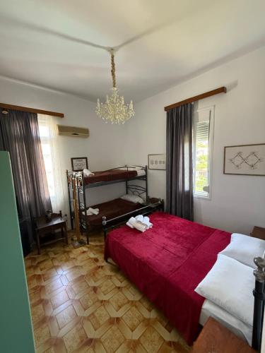 a bedroom with a red bed and a chandelier at Tower Traditional Pool Villa in Kremasti