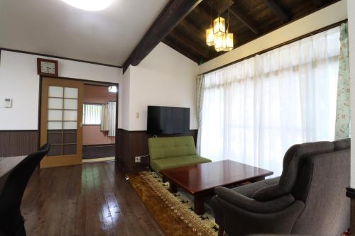 a living room with a couch and a table at 別荘五岳 in Minami Aso