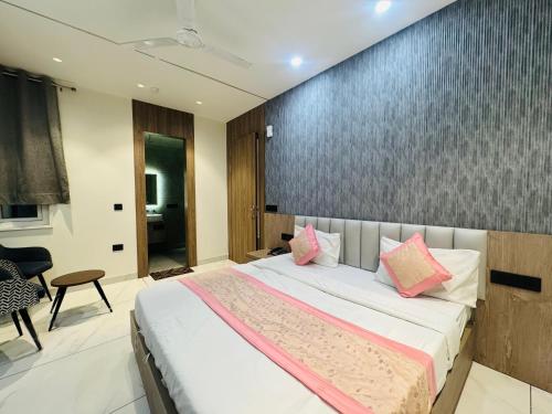 a bedroom with a large bed with pink pillows at Hotel 7 Star Rohini Sector 22 in New Delhi